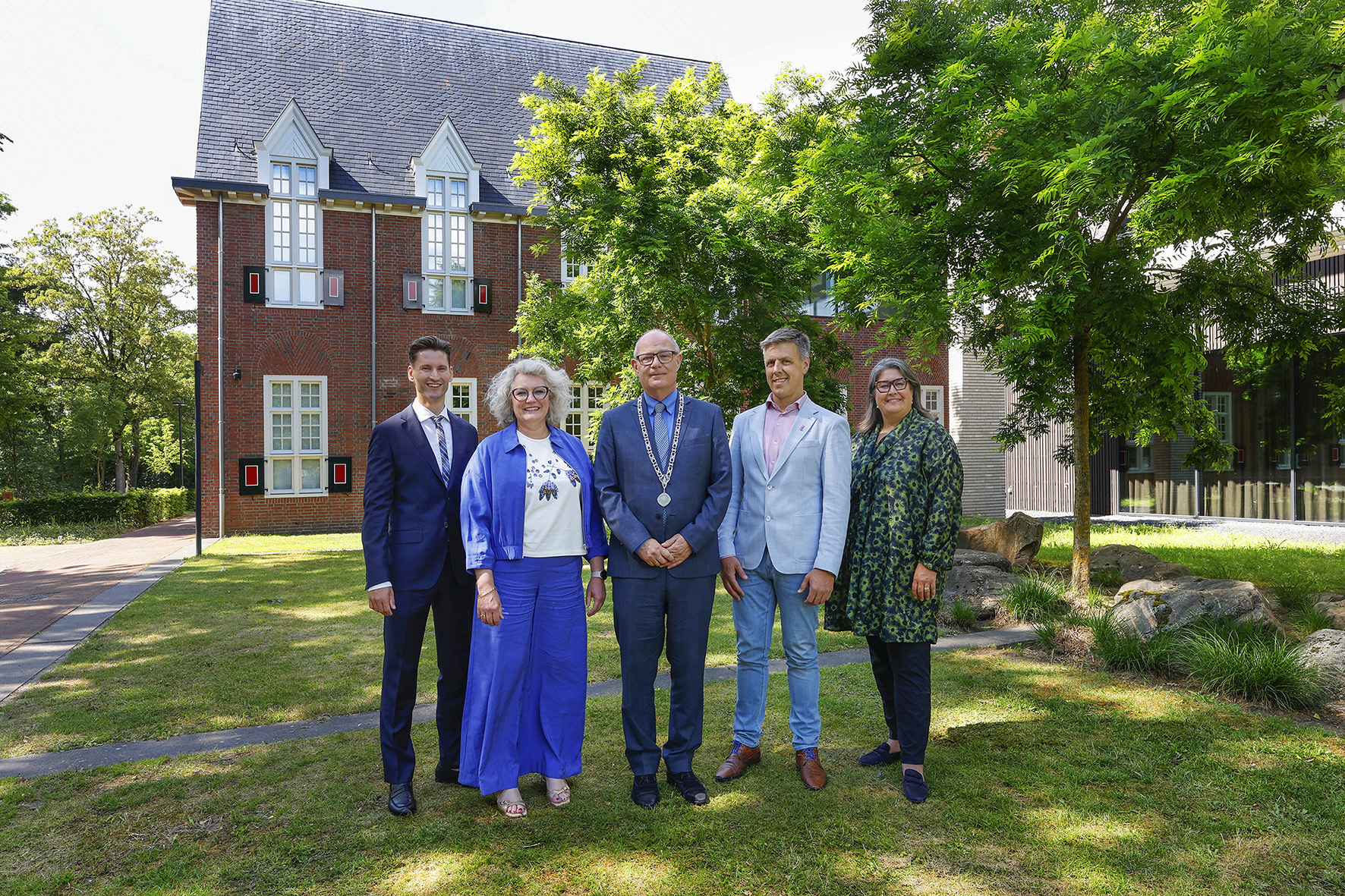 De burgemeester, wethouders en gemeentesecretaris aan de zijkant van Het Huis van Waalre